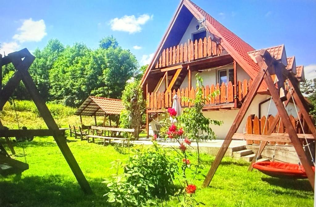 a house with a deck on a green yard at Wspaniały Zakątek in Sędziszowa