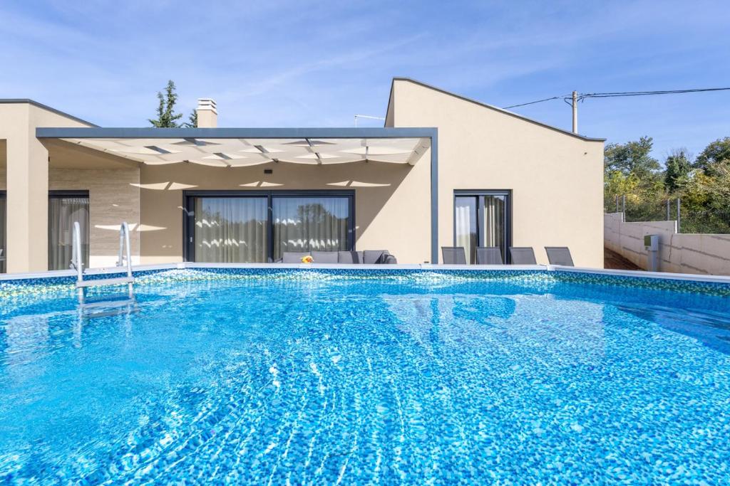 a swimming pool in front of a house at Casa Mia in Rebići