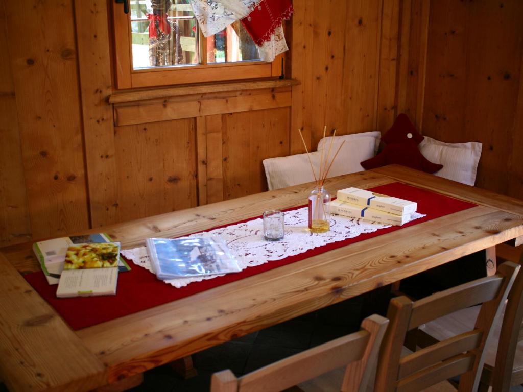 ベッラモンテにあるFascinating Cottage in Bellamonte with Saunaの赤いテーブルクロスを備えた木造キャビンのテーブル