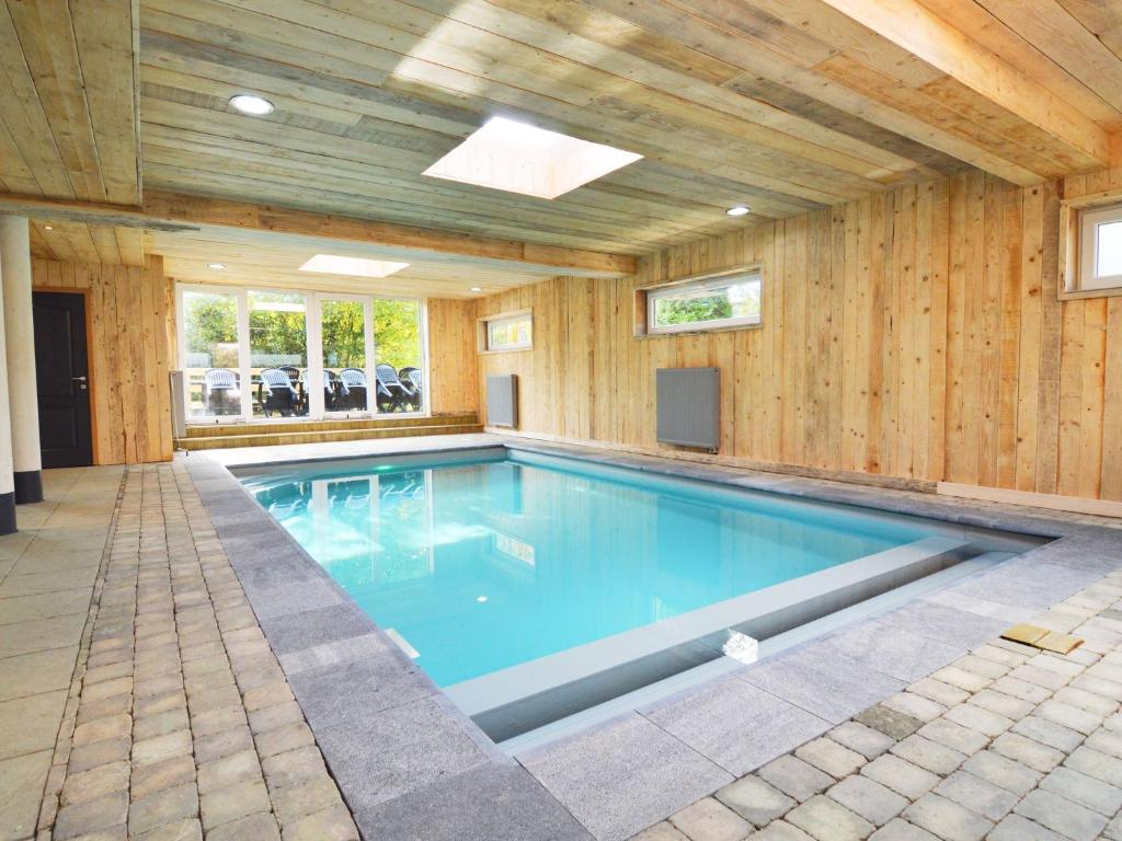 a large swimming pool with a wooden wall at Appealing holiday home in Malm dy with indoor pool in Malmedy