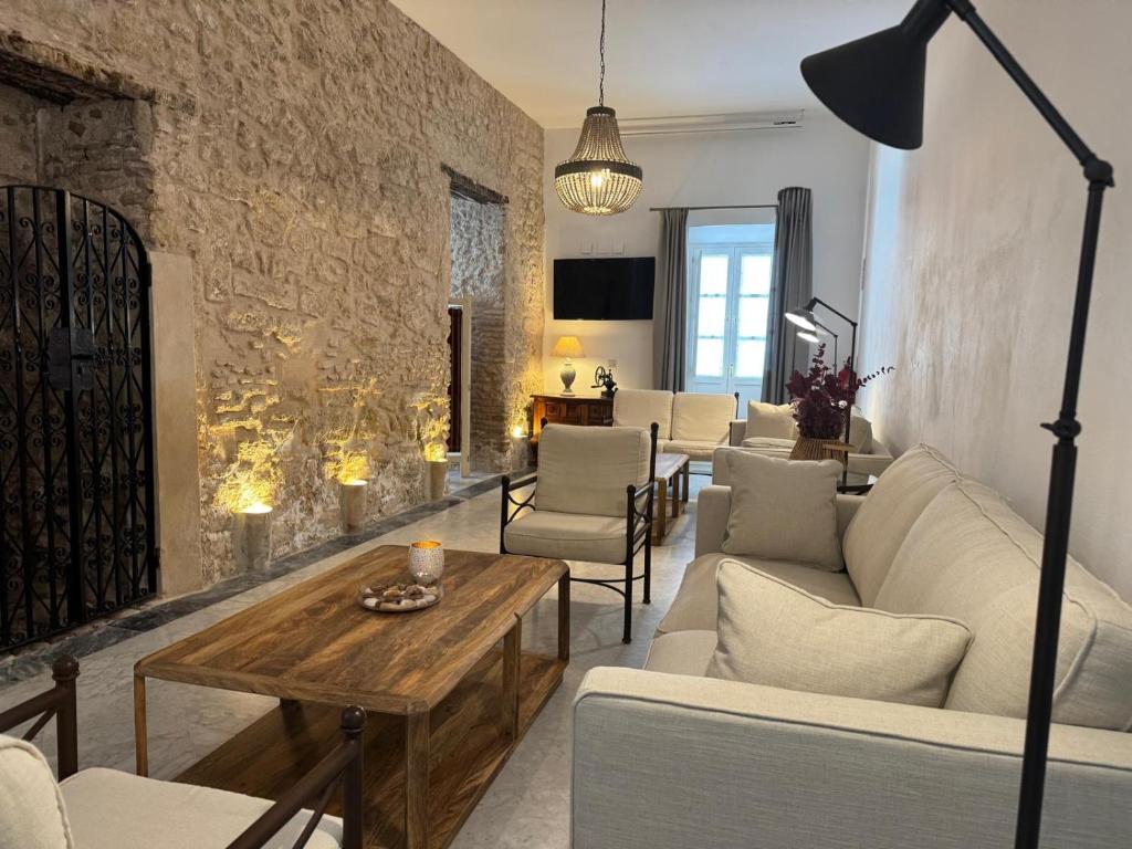 a living room with a couch and chairs and a table at Hotel Tugasa Casa Palacio Medina Sidonia in Medina Sidonia