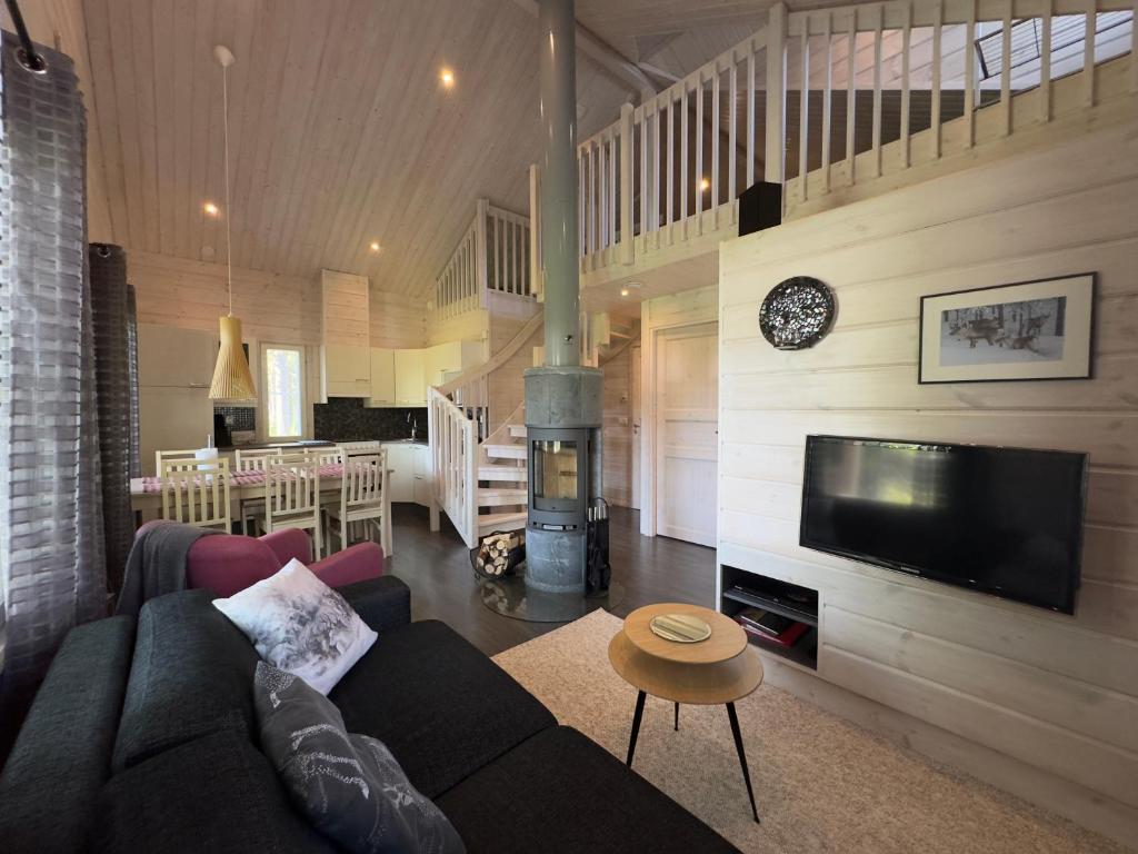 a living room with a couch and a fire place at Lumilyhty A in Äkäslompolo