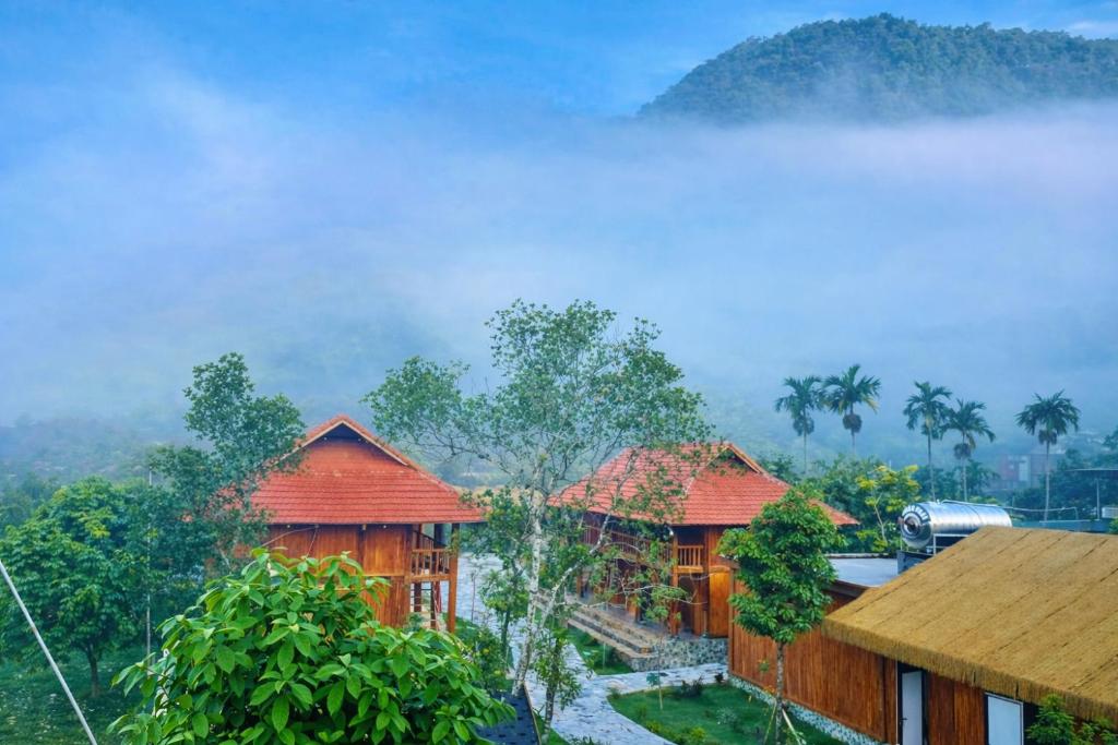 a view of two wooden buildings in the clouds at Khu du lịch nghỉ dưỡng Thạch Lâm Retreat in Thanh Hối