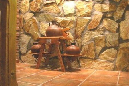 a stone wall with two tea pots on a stool at Hostal la Cepa in Aldeanueva de Ebro