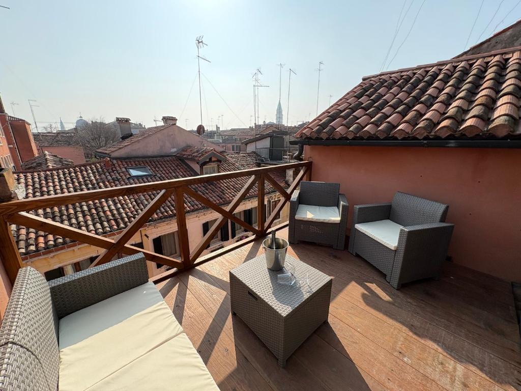a balcony with chairs and tables on a roof at Ca' del Pope in Venice