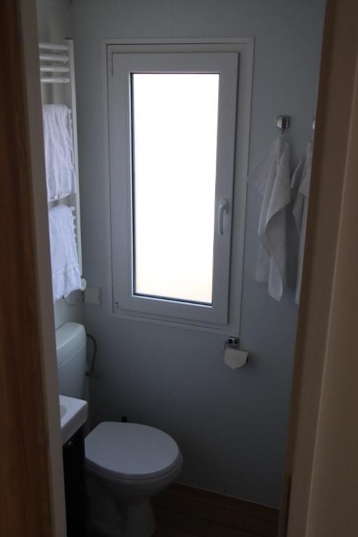 a bathroom with a white toilet and a window at Lillstugorna in Ljungskile