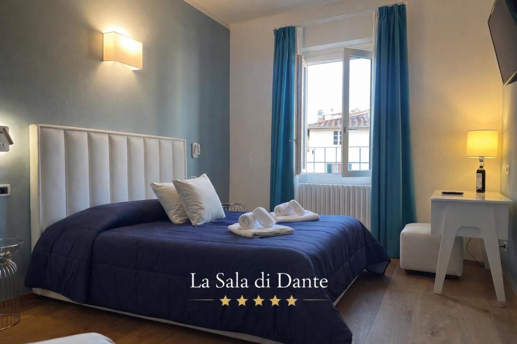 a bedroom with a blue bed and a window at "La Sala di Dante" Wi-Fi, Smart Tv, AC, Bagno Privato in Pistoia