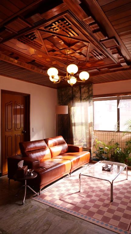 a living room with a leather couch and a table at yua sugar home in Daegu