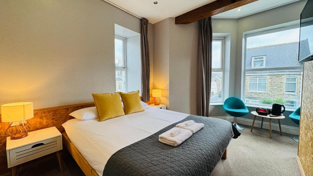 a bedroom with a bed with two towels on it at Town Lodge in Newquay