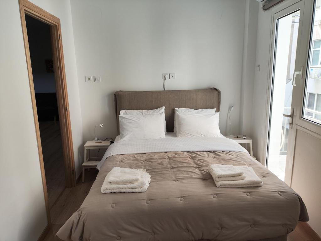 a bedroom with a large bed with two towels on it at Ulysses Apartments Ermou in Athens