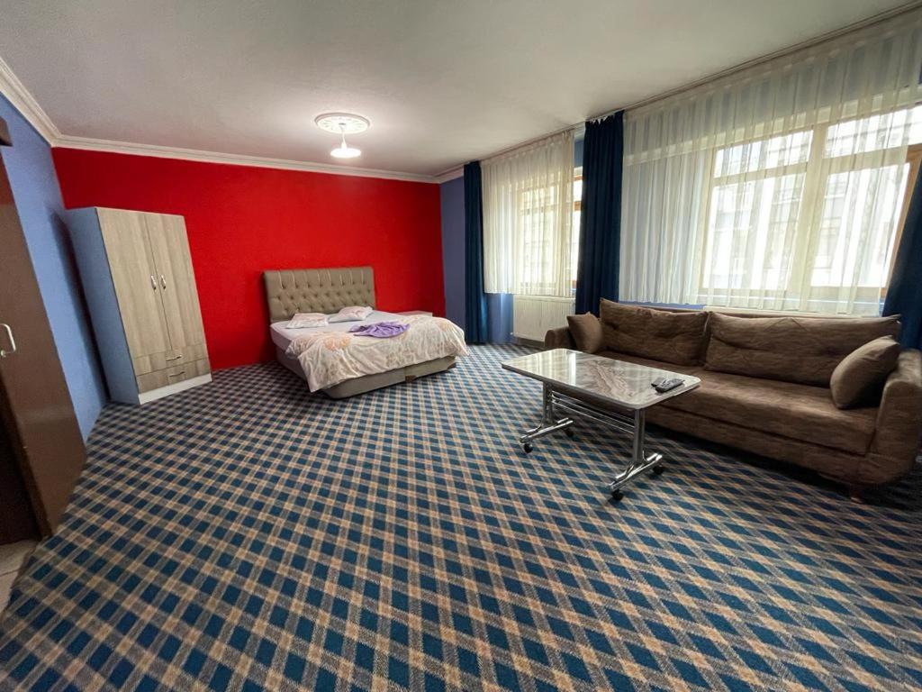 a living room with a couch and a table at Kutlu suit otel in Eskiömerler