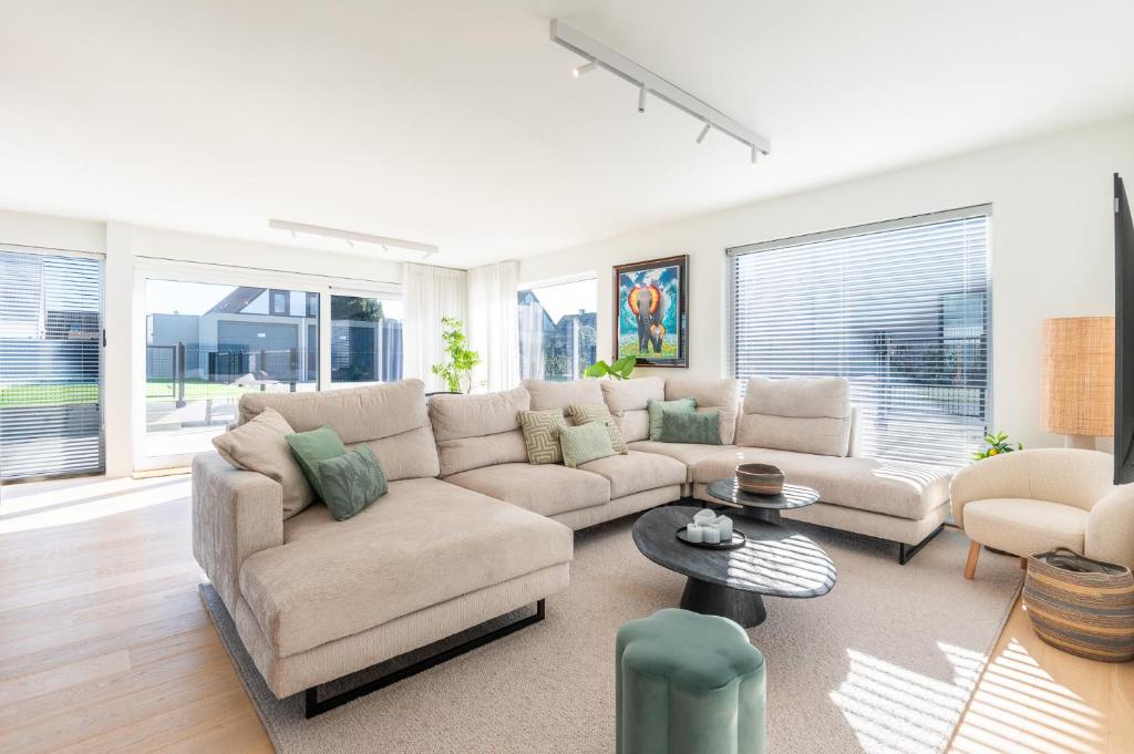 a living room with a couch and a table at Luxury Apartment with 4 Rooms, Pool and Modern Comfort in De Haan