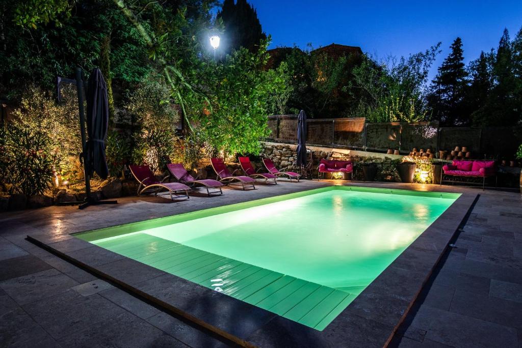 a swimming pool in a backyard at night at Le Roc sur l'Orbieu in Saint-Pierre-des-Champs