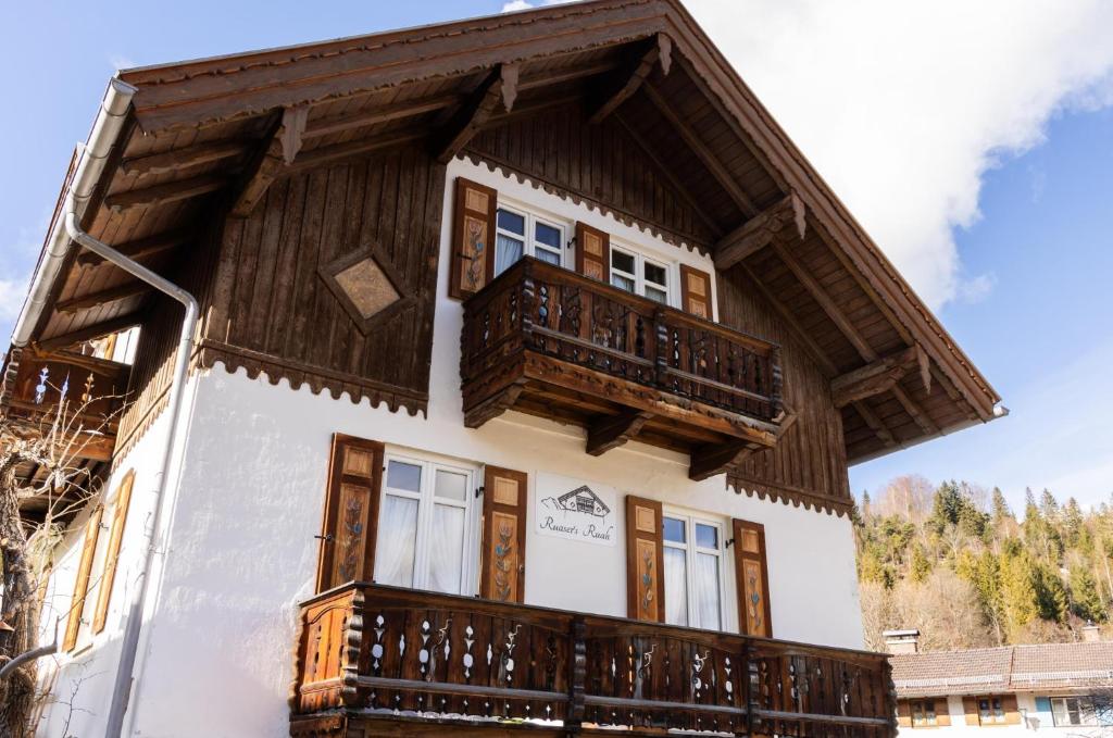 a house with wooden balconies on the side of it at Ferienwohnungen Ruasers Ruah in Mittenwald