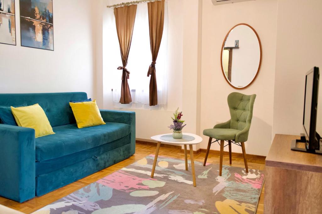 a living room with a blue couch and a chair at Apartman VIK in Brzeće