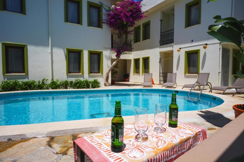 a table with wine bottles and glasses next to a swimming pool at The Dalyan's in Dalyan