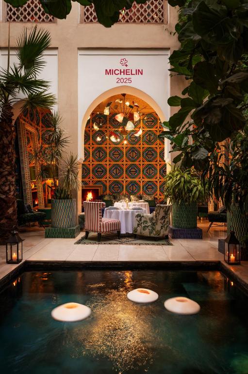 a pool in the middle of a building with a table at Riad Due in Marrakesh