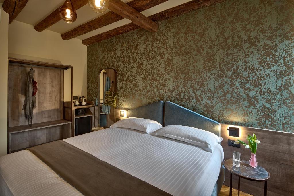 a bedroom with a large bed and a wall with floral wallpaper at Residenza Favaro in Venice
