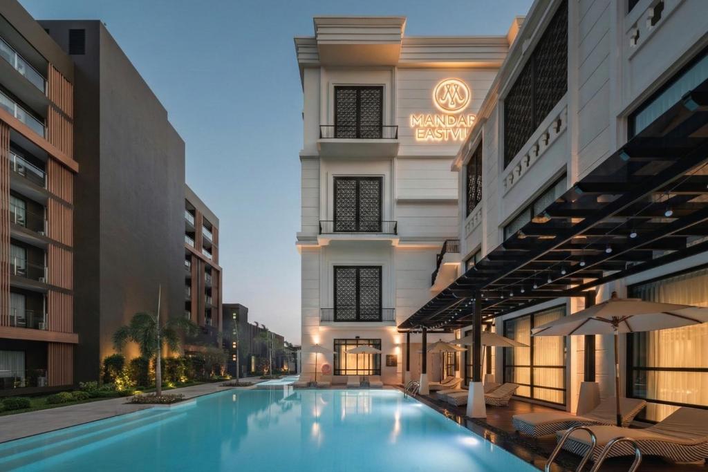 a swimming pool in front of a building at Mandarin Eastville, Pattaya - SHA Extra Plus in North Pattaya