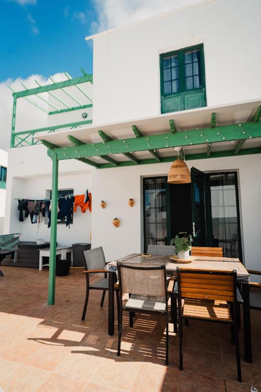 a patio with a table and chairs and a building at Vivilanza Surfhouse in Costa Teguise