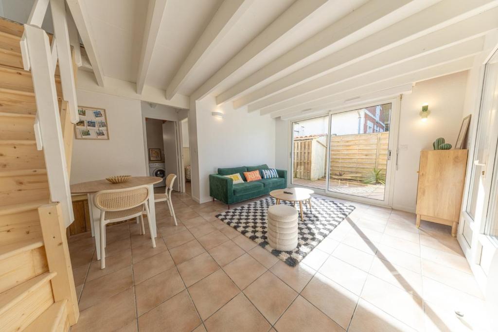 a living room with a table and a couch at Les Mimosas in Ronce-les-Bains