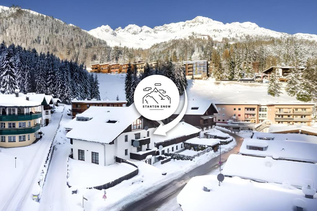 a resort in the mountains with snow on the roofs at StAnton Snow in Sankt Anton am Arlberg