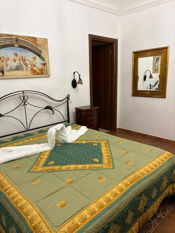 a bedroom with a bed with a gold and green bedspread at B&B Mirabella Rooms Ortigia in Syracuse