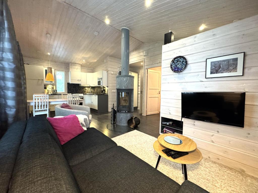 a living room with a couch and a fireplace at Lumilyhty B in Äkäslompolo