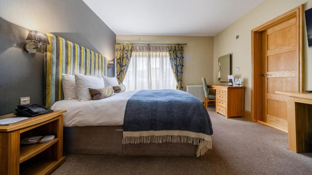 a bedroom with a large bed with a blue blanket at Ennios Boutique Hotel in Southampton