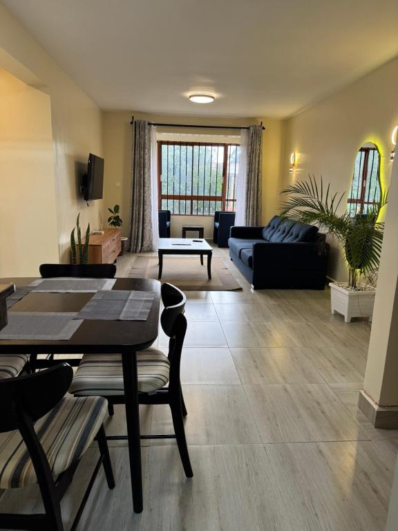 a living room with a table and a couch at Raha Home within Nakuru CBD with pool and gym in Nakuru