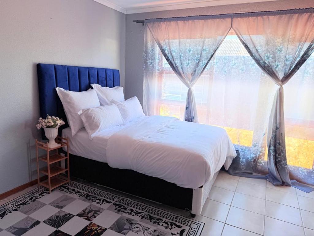 a bedroom with a large bed and a window at Zahies Accommodation in Panorama