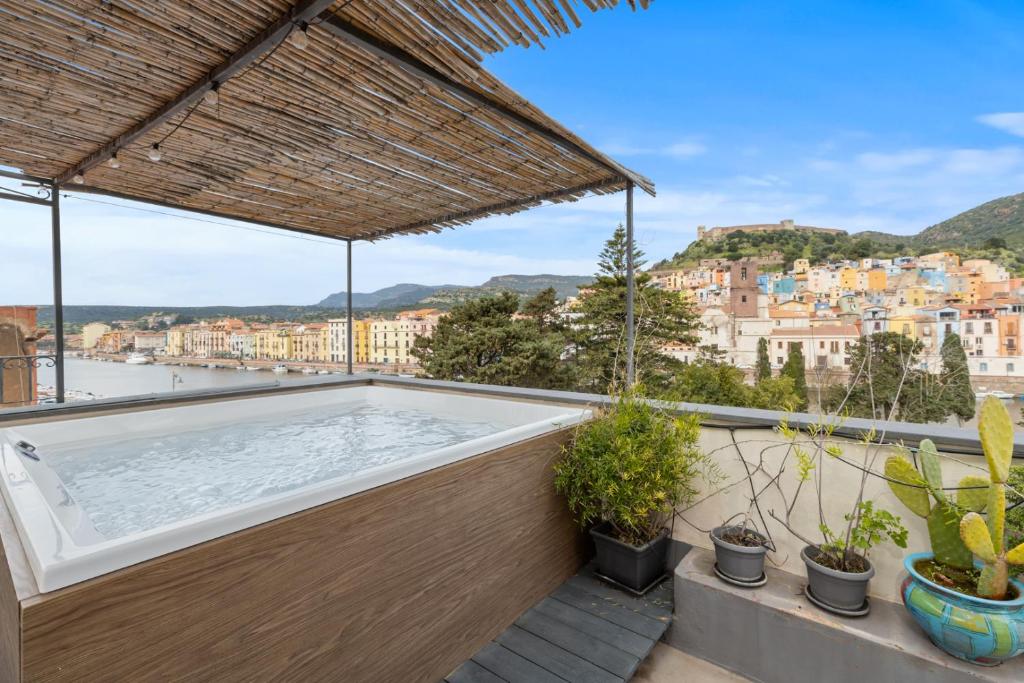 a hot tub on top of a balcony with plants at Bosa Eye House 1873 in Bosa