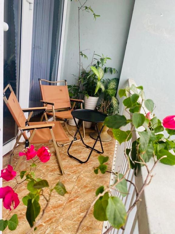 a room with two chairs and a table and flowers at Kavy Homestay in Thôn Trường Giang