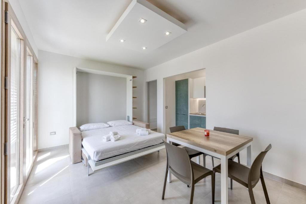 a bedroom with a bed and a table and chairs at La Spiaggetta 2 in Torre San Giovanni Ugento