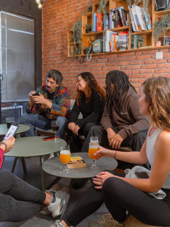 a group of people sitting around a table with drinks at Olé Backpackers Hostel in Alicante