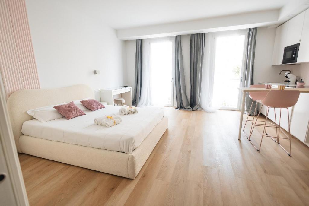 a bedroom with a white bed and a wooden floor at City Boutique in Porto Torres