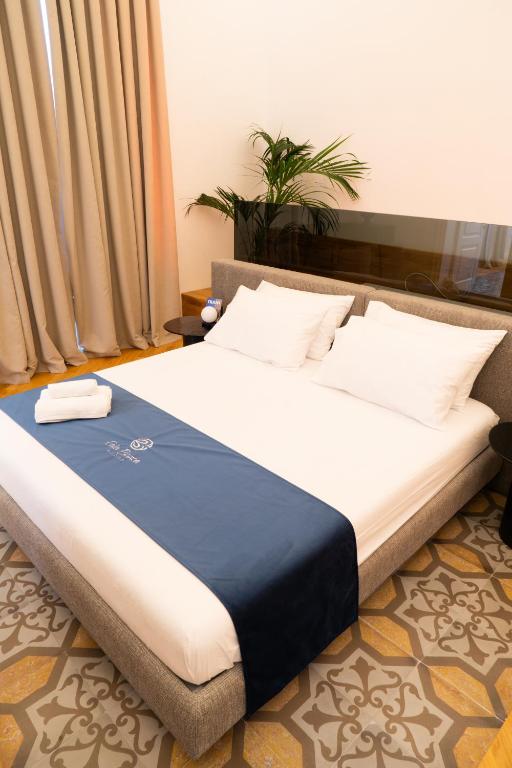 a bed with a blue and white blanket on it at Cala Bianca in Trani