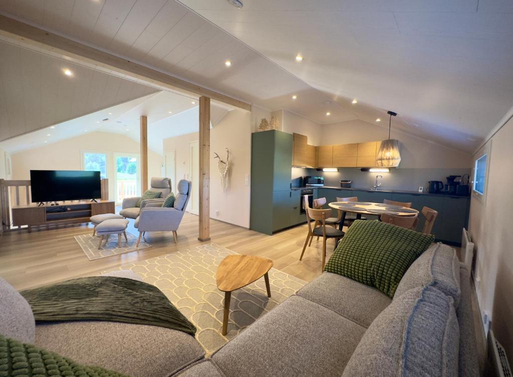 a living room with a couch and a dining room at Riihen Vintti in Äkäslompolo