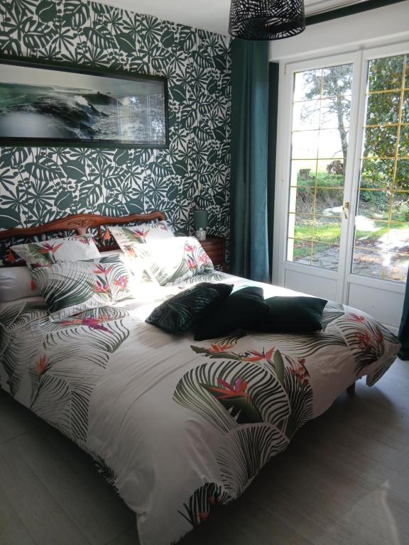 a bedroom with a bed with a colorful comforter at Chambre d hote bucolique in Mahalon