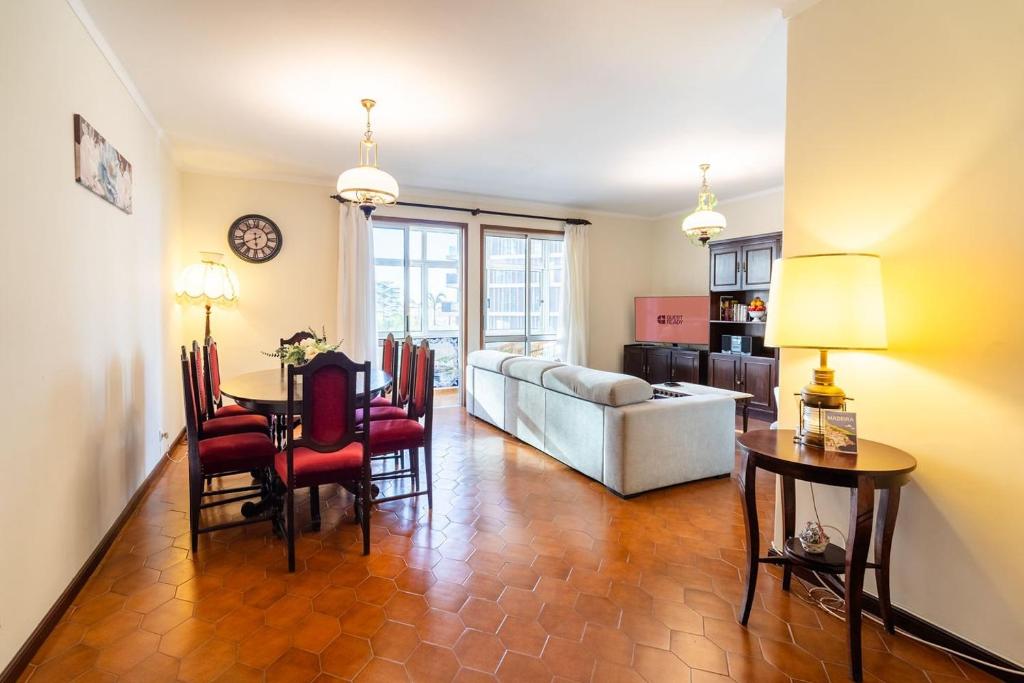 a living room with a table and a couch at GuestReady - Varanda de belas lembranças in Funchal