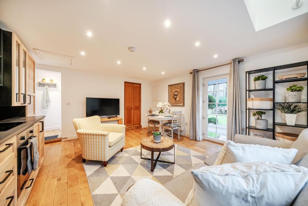 a living room with a couch and a table at Eagle's Nest in Worplesdon