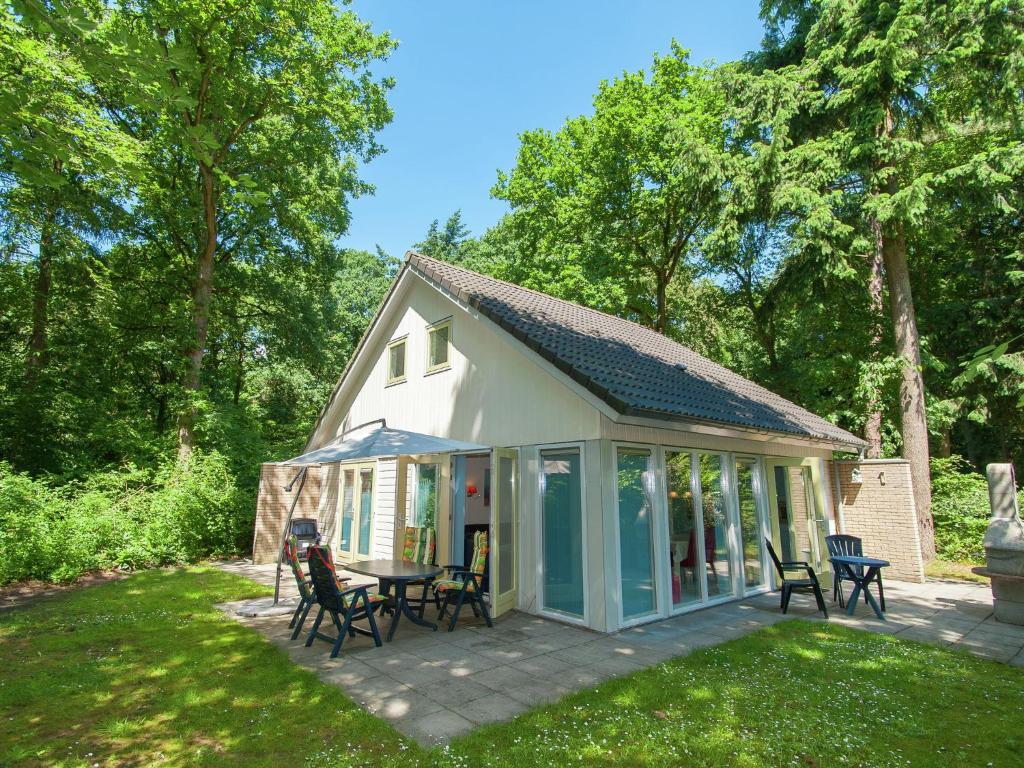 een paviljoen met stoelen en een tafel op een patio bij Villa with garden and fireplace in Oudemirdum