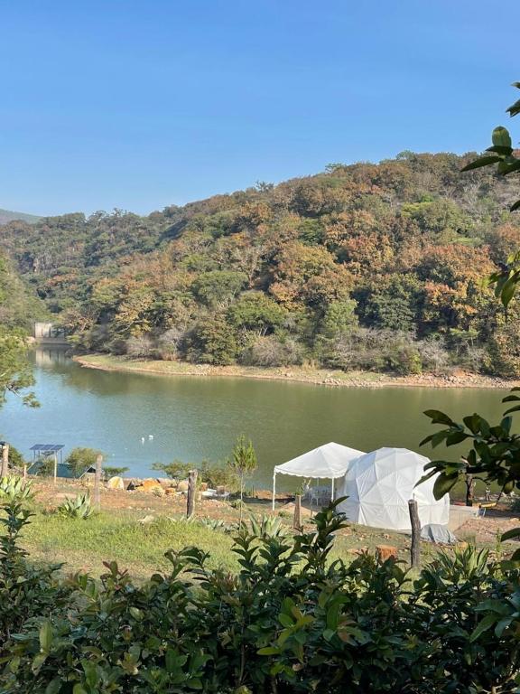 a white tent in front of a body of water at Glamping Mascota in La Providencia