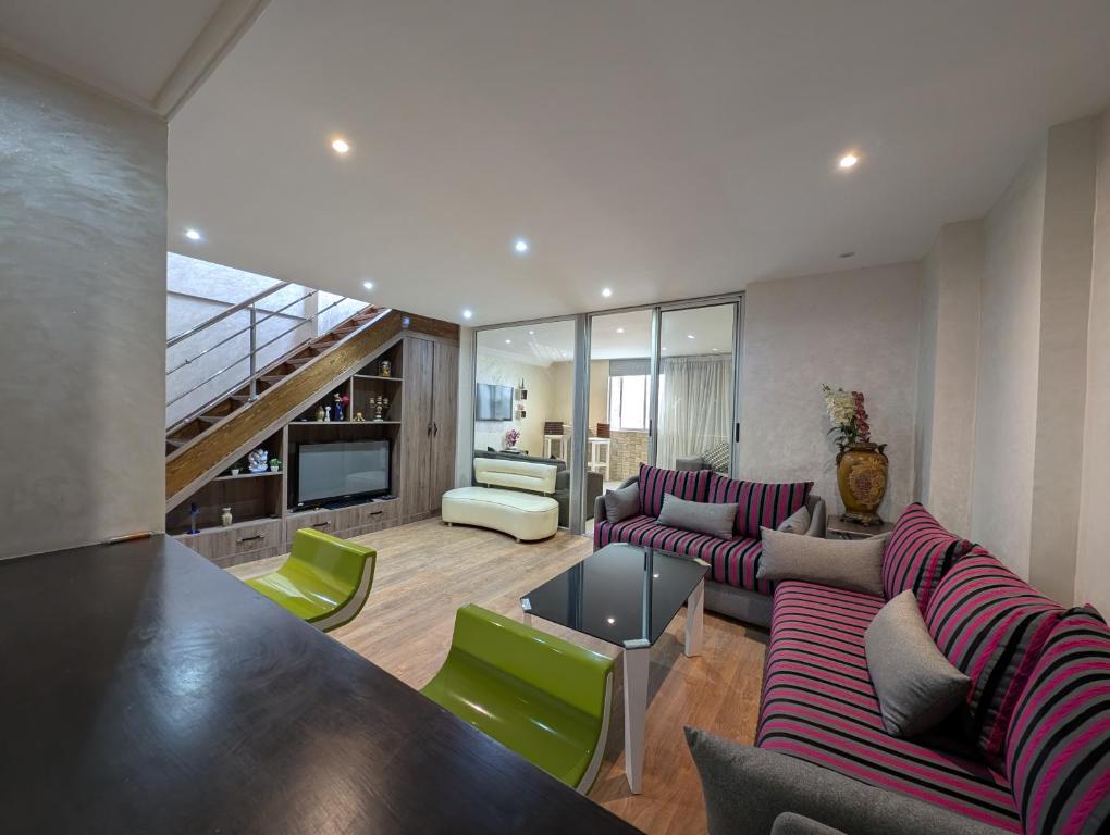 a living room with purple and green furniture at Tanger City 5 in Tangier
