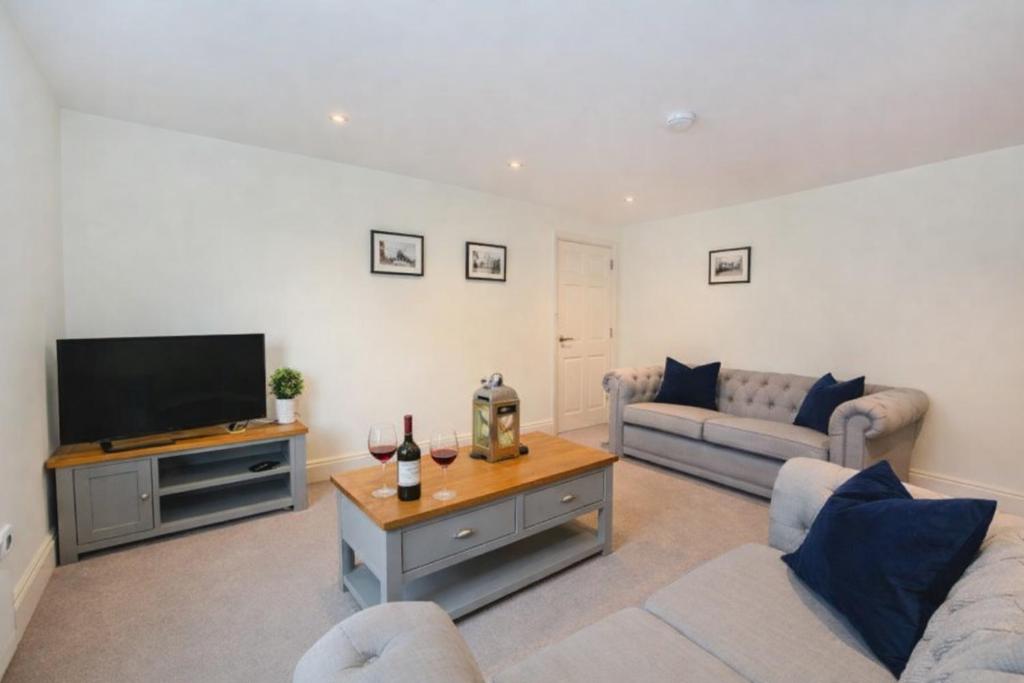 a living room with a couch and a television at Minster's Keep- Near York Minster & Free Parking in York