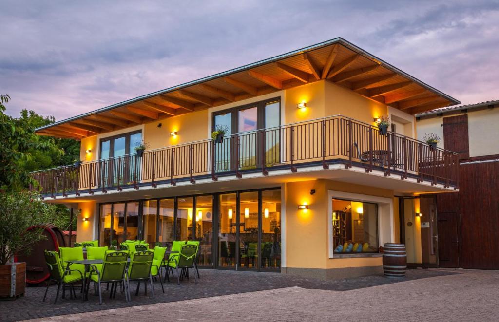 una casa con balcón y sillas verdes en Weingut Mussel, en Wörrstadt