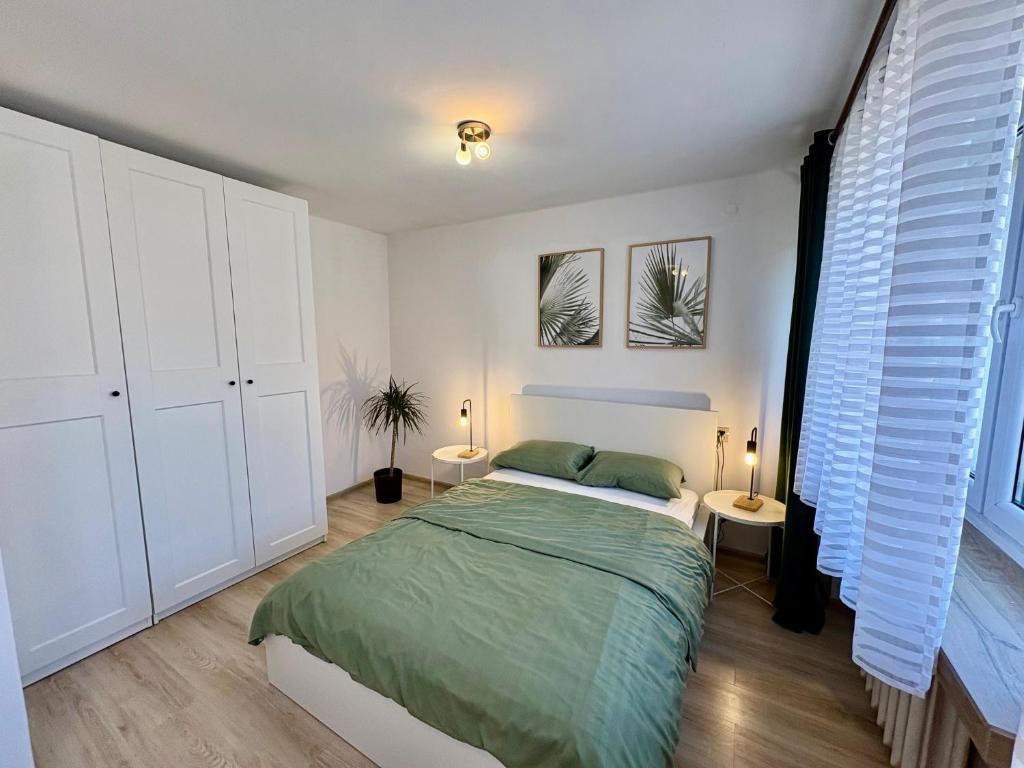 a bedroom with a bed and two tables and a window at Przy Zamenhofa in Nowa Sól