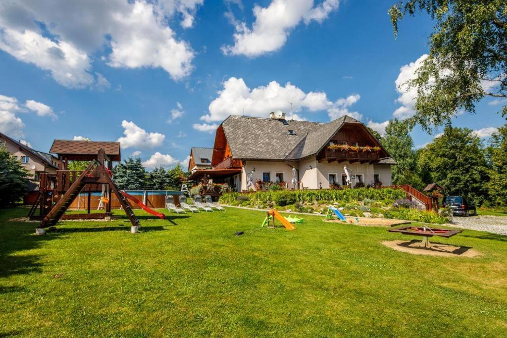 a yard with playground equipment in front of a house at Penzion pod Šerákem - celý objekt Ostružná - Jeseníky in Ostružná