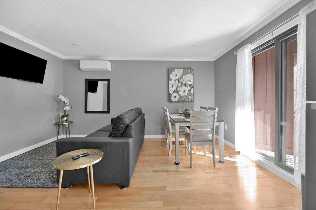 ein Wohnzimmer mit Sofa und Tisch in der Unterkunft Airport Subway Condo in Boston