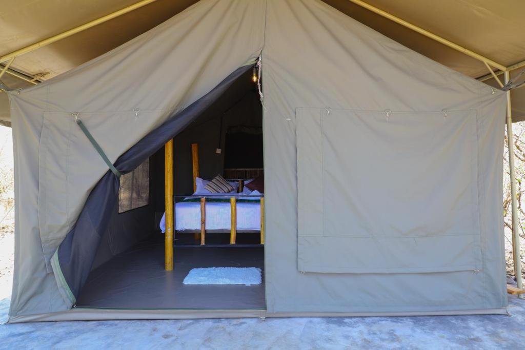a tent with a bed inside of it at Maasai Wild Adventure in Gatunga